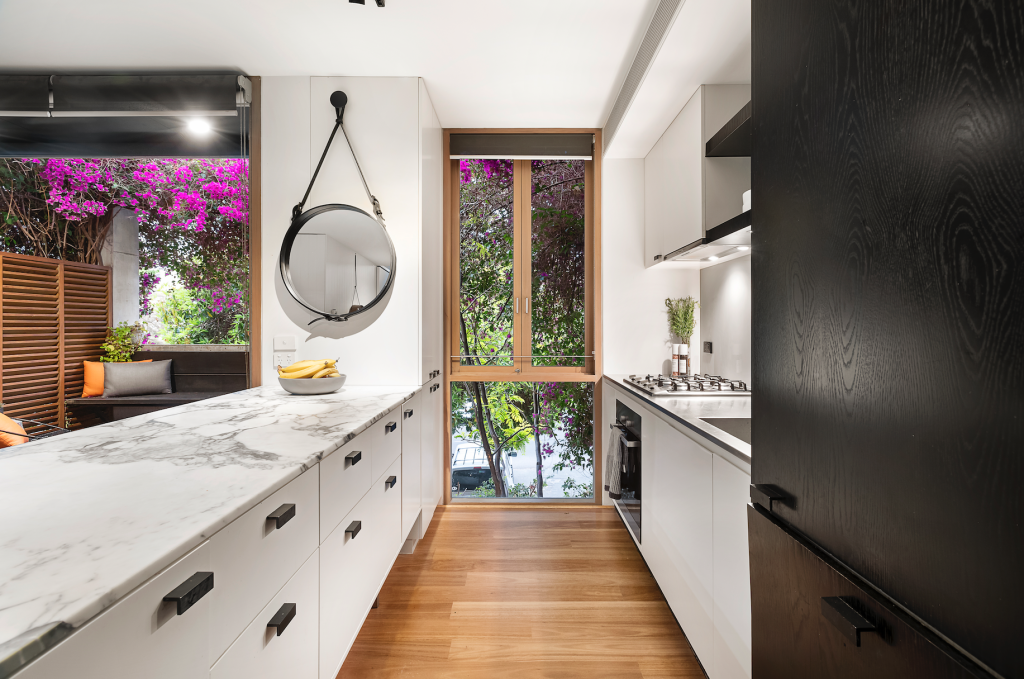 stylish kitchen with black cabinets and marble counter updated for 2024 trends
