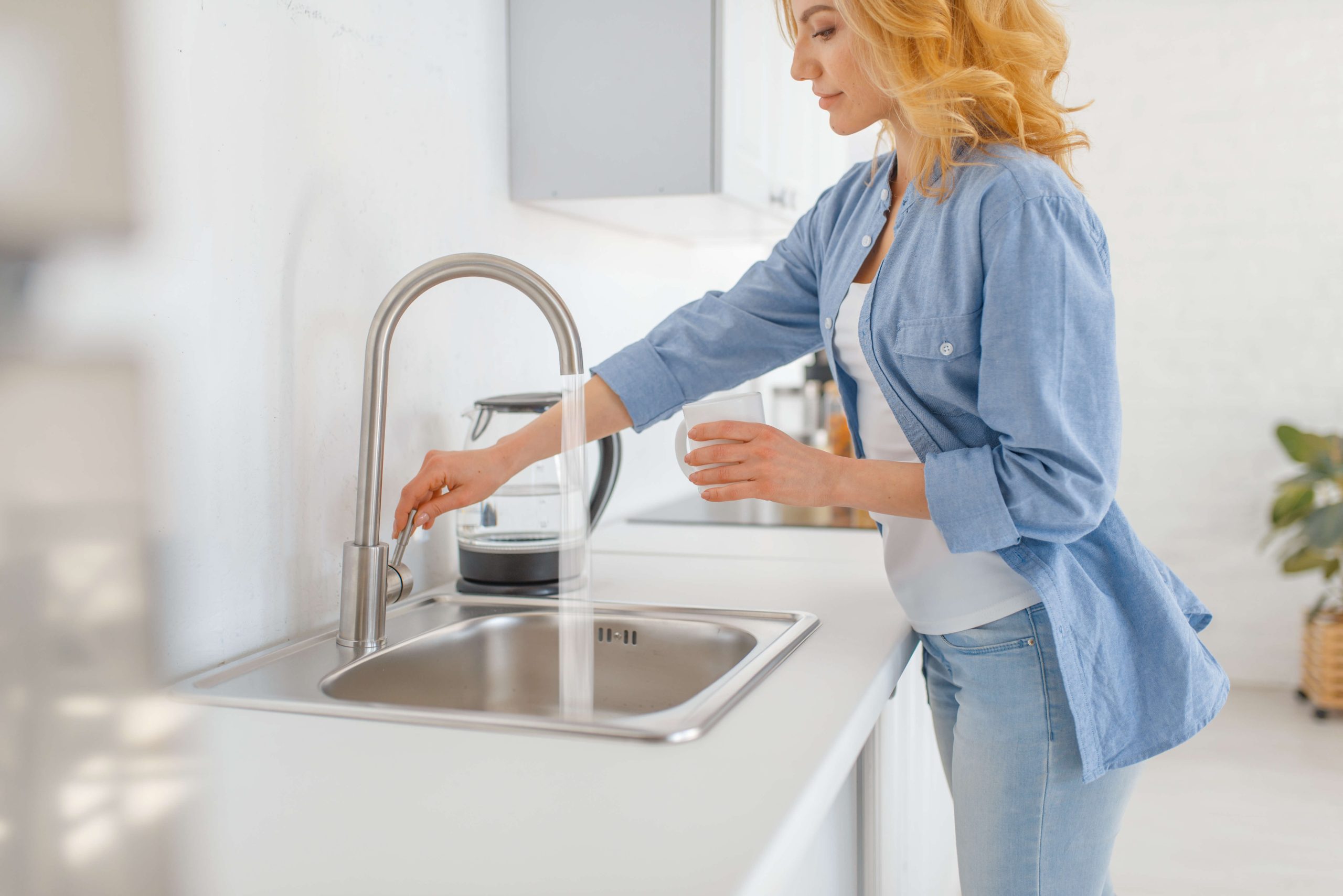 woman at kitchen sink cleaning garbage disposal