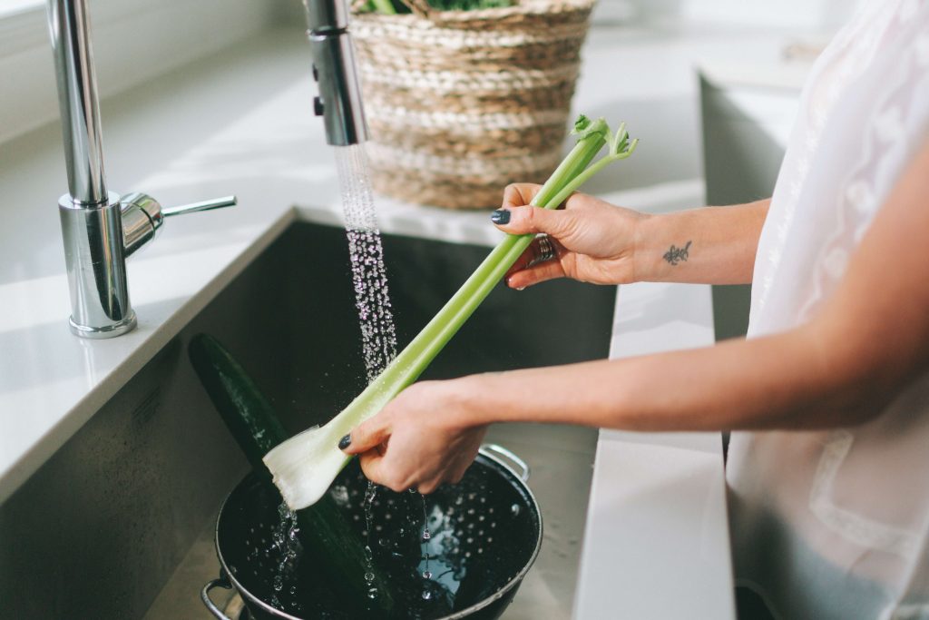 woman washing celery in drop-in kitchen sink