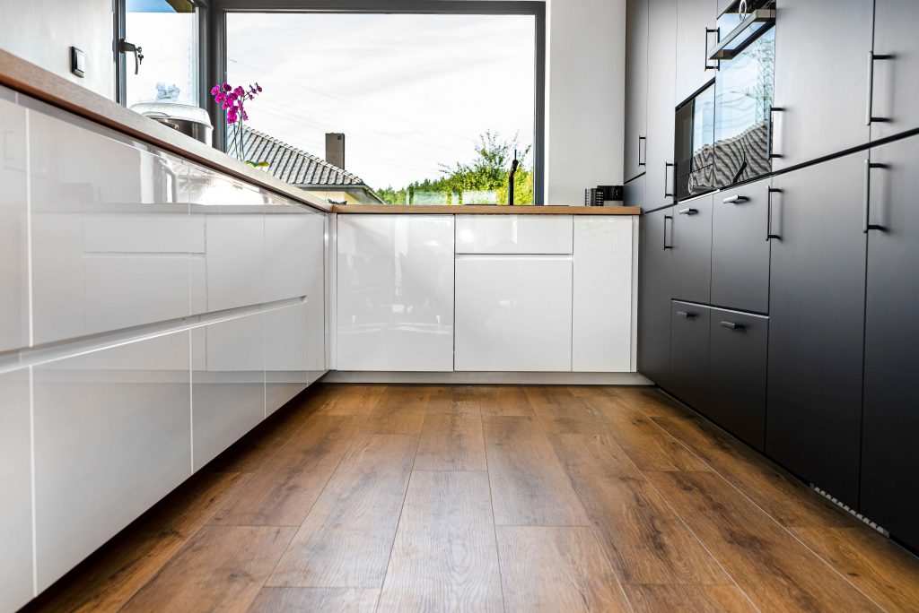 modern kitchen with luxury vinyl plank flooring and white and black cabinetry