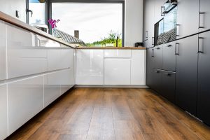 modern kitchen with luxury vinyl plank flooring and white and black cabinetry