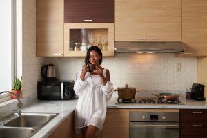 woman drinking coffee in white tiled kitchen