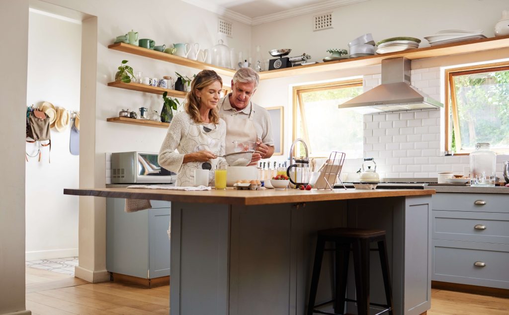 senior couple cooking dinner in newly remodeled kitchen