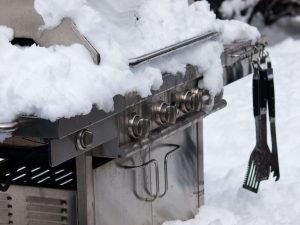 gas grill covered in snow in the winter