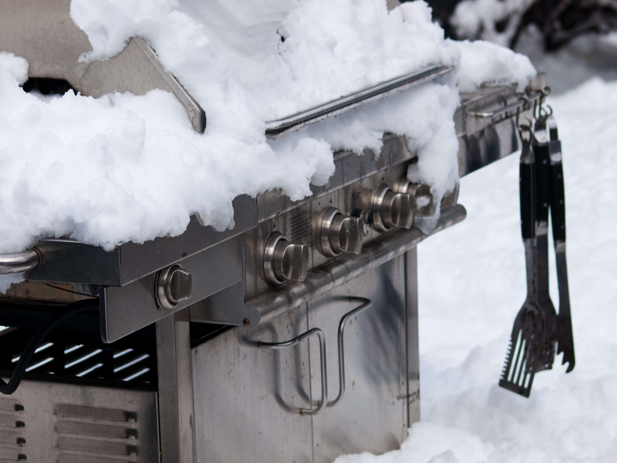 gas grill covered in snow in the winter